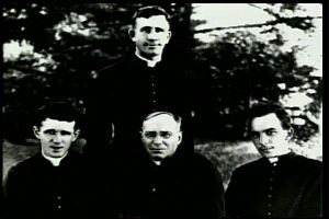 On September 7, 1918, the Catholic Foreign Mission Society of America holds its first Departure Ceremony. Fathers Francis X. Ford (seated, right), Bernard Meyer (standing), Thomas F. Price (seated, center) and James E. Walsh (seated, left) begin their journey to Maryknoll's new mission field in South China.